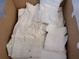 une boîte en carton remplie d'un grand nombre de vêtements blancs