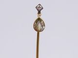 an image of a diamond and gold pendant on a stick