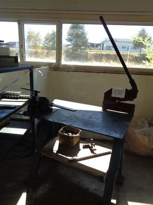 an image of a workbench in a room with a lot of clutter