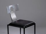 une chaise noire avec un dossier en métal et une assise noire