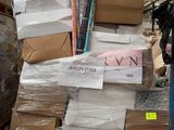 un homme debout à côté d'une pile de cartons dans un entrepôt