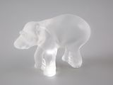 une sculpture en verre transparent représentant un ours, posée sur une table