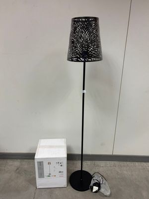 un lampadaire avec un abat-jour noir et une boîte blanche à côté
