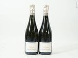 deux bouteilles de vin posées l'une à côté de l'autre sur une surface blanche