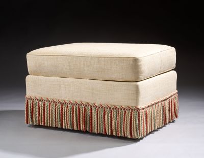 an upholstered ottoman with a red, white, and blue stripe skirt