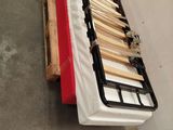 a bed with a wooden frame on a table in a warehouse