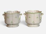 deux vases blancs ornés de motifs verts, placés l'un à côté de l'autre