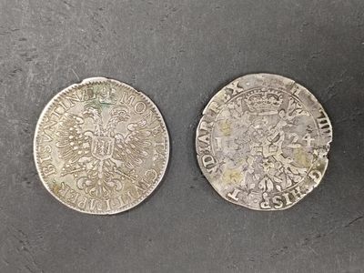 two silver coins sitting on top of a table next to each other