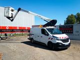 un camion blanc garé devant un bâtiment sur lequel est installée une grue