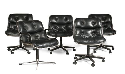 quatre fauteuils de bureau en cuir noir posés sur des roulettes, sur une surface blanche