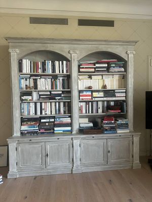 a large bookshelf in the middle of a living room with a flat screen tv