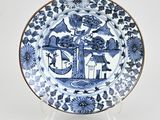 une assiette bleue et blanche sur laquelle est représentée une maison