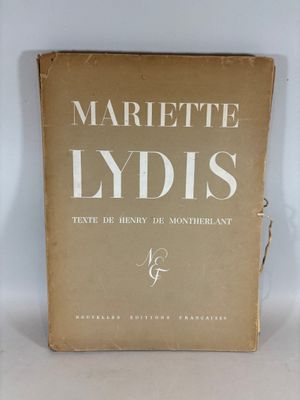 un vieux livre posé sur une table à côté d'un mur blanc