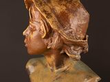 statue of a woman wearing a hat on a wooden table