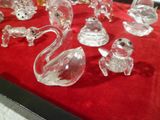 de nombreuses figurines en verre posées sur une table rouge