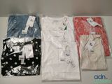 three shirts are sitting on a table with price tags on them