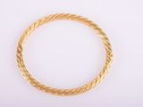 a close up of a gold bracelet on a white surface