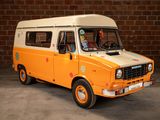an orange and white van parked in front of a brick wall