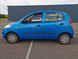 a small blue car that is parked in a parking lot