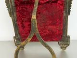 a small red chair with a gold frame on it