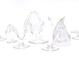 many pieces of glass sitting on a white surface
