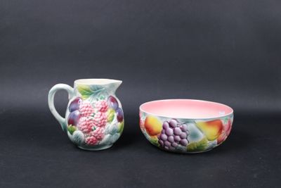 two bowls and a pitcher on a black background
