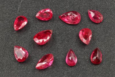 a group of ruby colored gems on a black surface