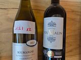 three bottles of wine are lined up on a shelf next to a bottle of wine