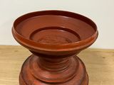 a brown bowl on a wooden table with a white wall in the background