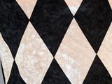 a black and white checkered pillow on the floor