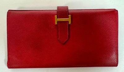 a red leather wallet with a gold clasp on it