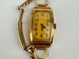 an image of a gold wrist watch with a chain around it