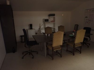 une pièce équipée d'une table, de chaises et d'un micro-ondes