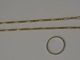 two gold chains and a ring on a white surface