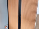 a closet in the corner of a room with books on the floor