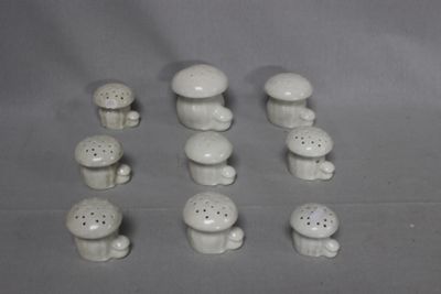 a lot of small white ceramic mushrooms on the table