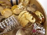 a wooden bowl filled with lots of gold and silver jewelry