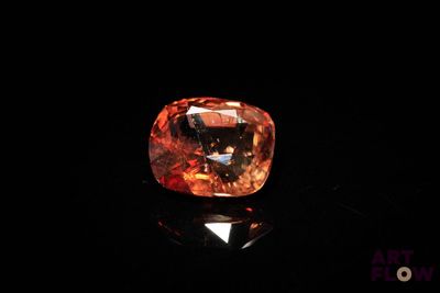 an orange diamond on a black surface