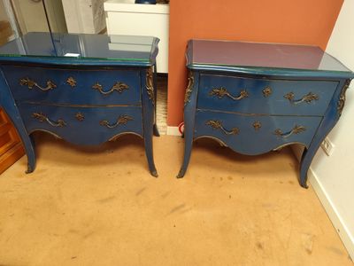 une paire de tables de chevet peintes en bleu dans une chambre aux murs orange