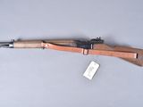 an old rifle with a wooden barrel on a gray surface
