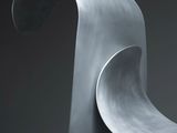 a close up of a metal sculpture on a black surface
