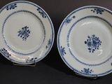 three blue and white plates with flowers on them sitting on a table