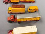 cinq camions miniatures alignés sur une table