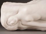 a white statue of a woman laying down on a table