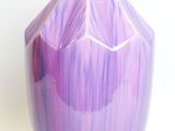 purple vase on a white surface with a white background