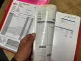 a person that is holding a book that has a receipt in it