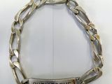 silver plated bracelet with engraved name on it on a white surface