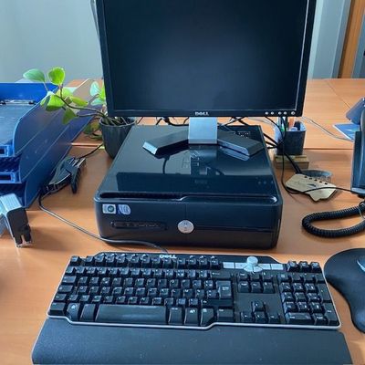 un ordinateur de bureau posé sur une table à côté d'un clavier et d'une souris