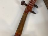an old violin sitting on top of a white table next to a couch