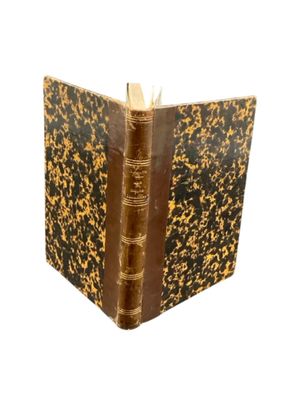 an old book with a brown cover sitting on top of a white surface